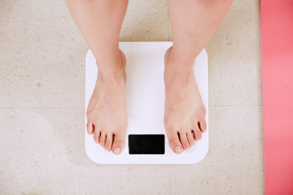 Person standing on weight-measuring scales 