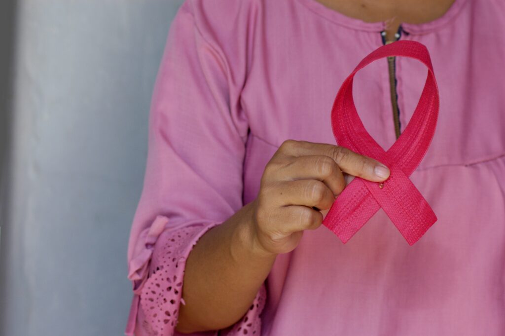 Woman holding the pink breast cancer awareness ribbon loop