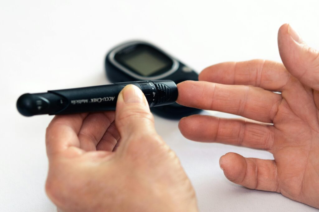 A person uses a pin-prick monitor to measure blood glucose 