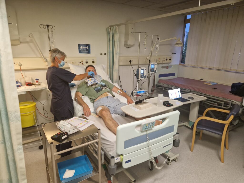 Study participant lying on a hospital bed attended to by a nurse