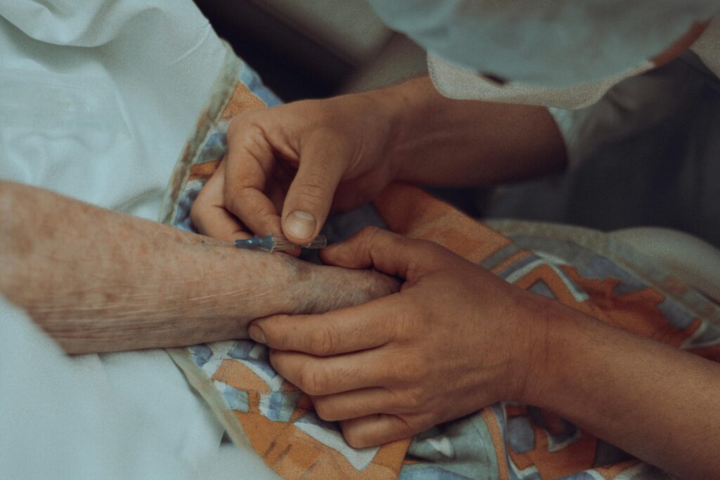 hands of nurse with syringe and arm of elderly person