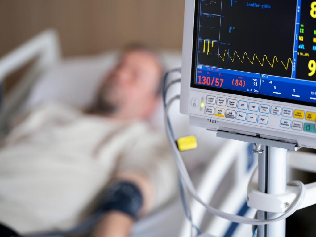 Man on hospital bed being monitored with an electrocardiogram 
