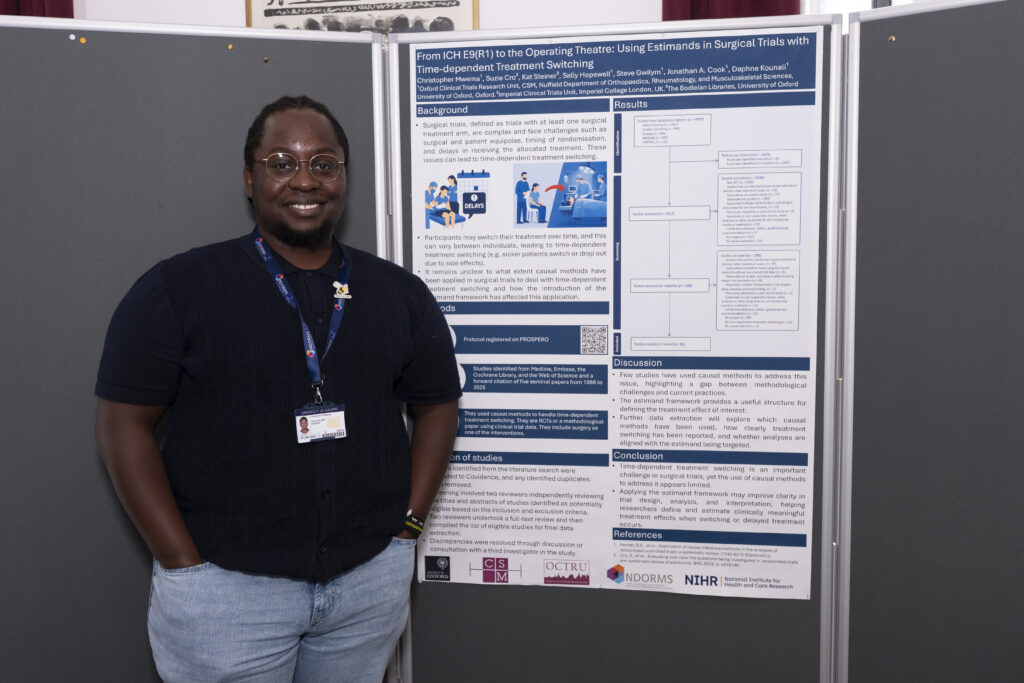 Christopher Mwema standing smiling in front of his poster