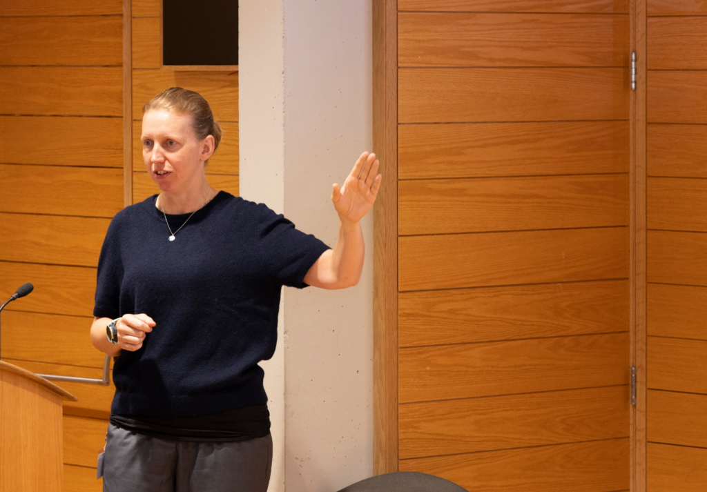 Helen Knott speaking at the symposium and gesturing with her hand