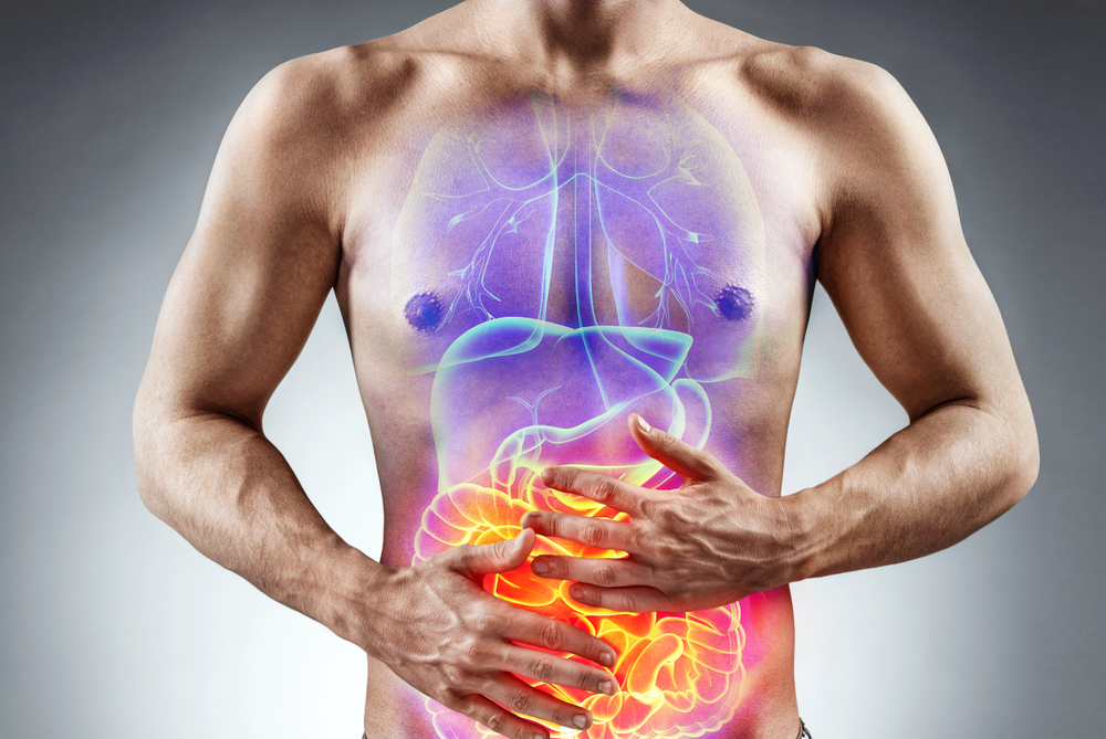 conceptual image showing man holding his stomach in pain.