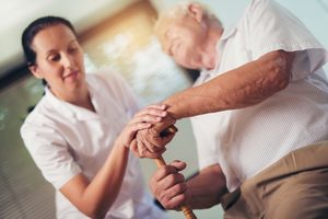 Young,Woman,Holding,Hand,Of,Old,Man,With,Walking,Stick